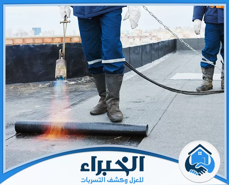 فنيون ينفذون عزل مائي للأسطح باستخدام لفائف البيتومين والحرارة لتكوين طبقة مقاومة لتسرب المياه.