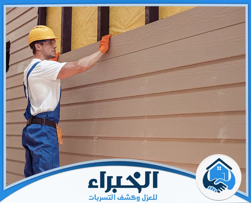 فني يقوم بتركيب ألواح كسوة خارجية بتصميم خشبي على واجهة مبنى ضمن أعمال تركيب الكلادينج بالرياض.